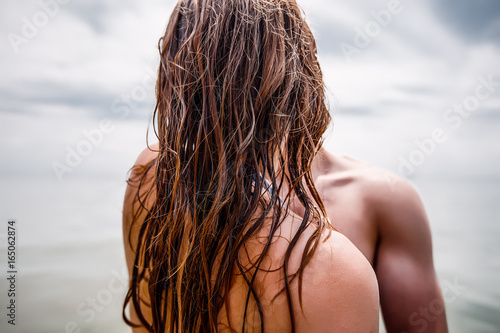 Sexy couple at sea,slim body,long hair,swimwear,swimsuit,beautiful tan,summer holidays concept,make up,bearded man