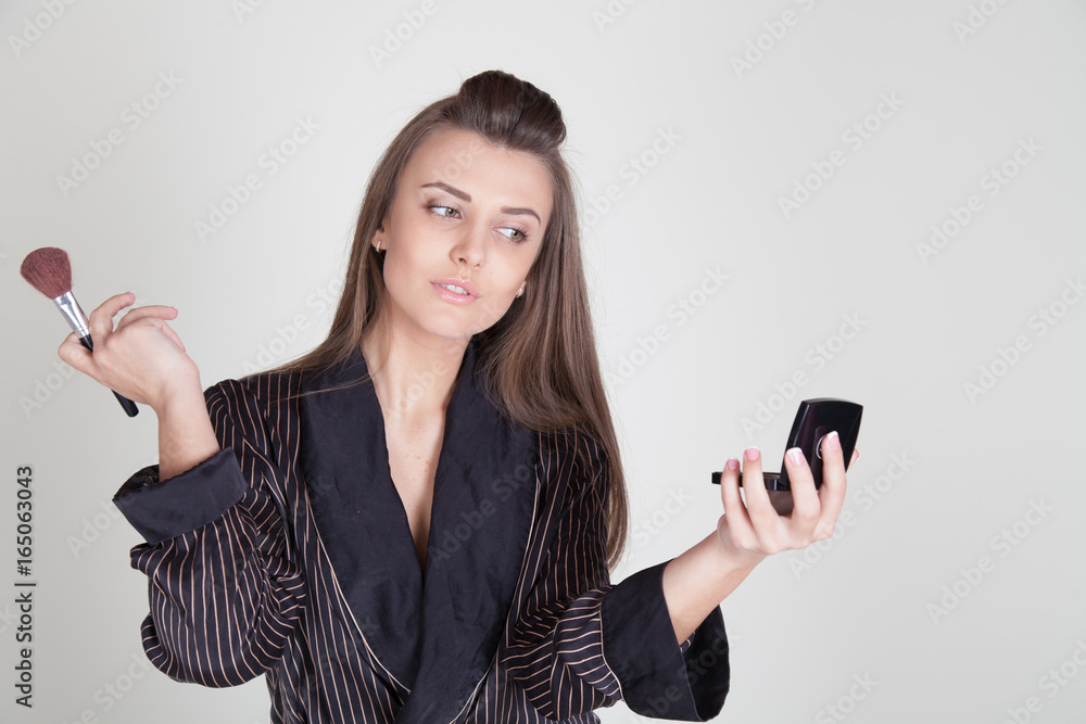 girl in coat makes brush makeup looks in the mirror girl in coat makes brush makeup looks in the mirror