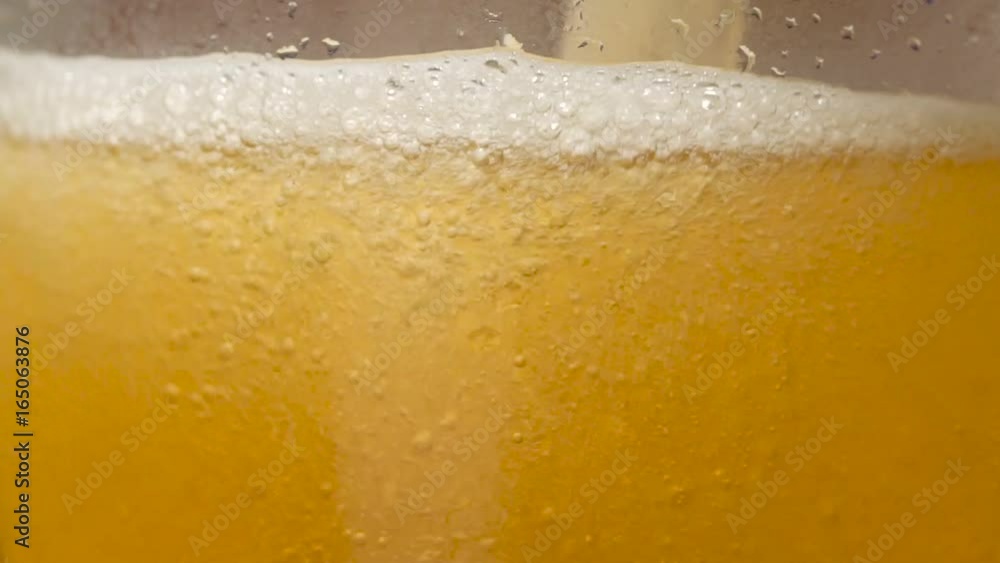 Extreme close-up beer bubbles in a glass while being poured Extreme close-up beer bubbles in a glass while being poured
