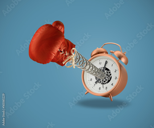 Red boxing glove on spring coming out of alarm clock
