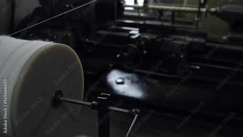 The worker rotateting the drum handle with threads The worker rotateting the drum handle with threads