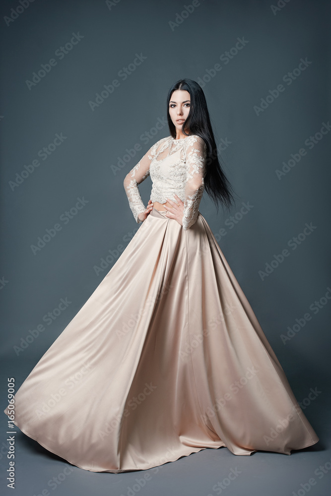 Beautiful girl to dress on brown background.