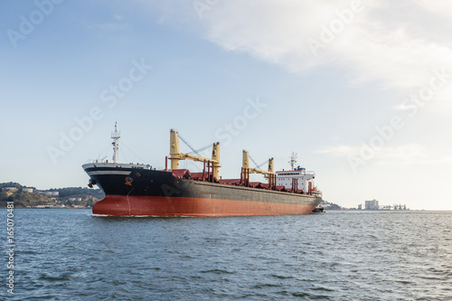 Cargo ships in river being tugged