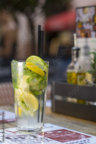 A glass of cold mint lemonade with lemon and lime