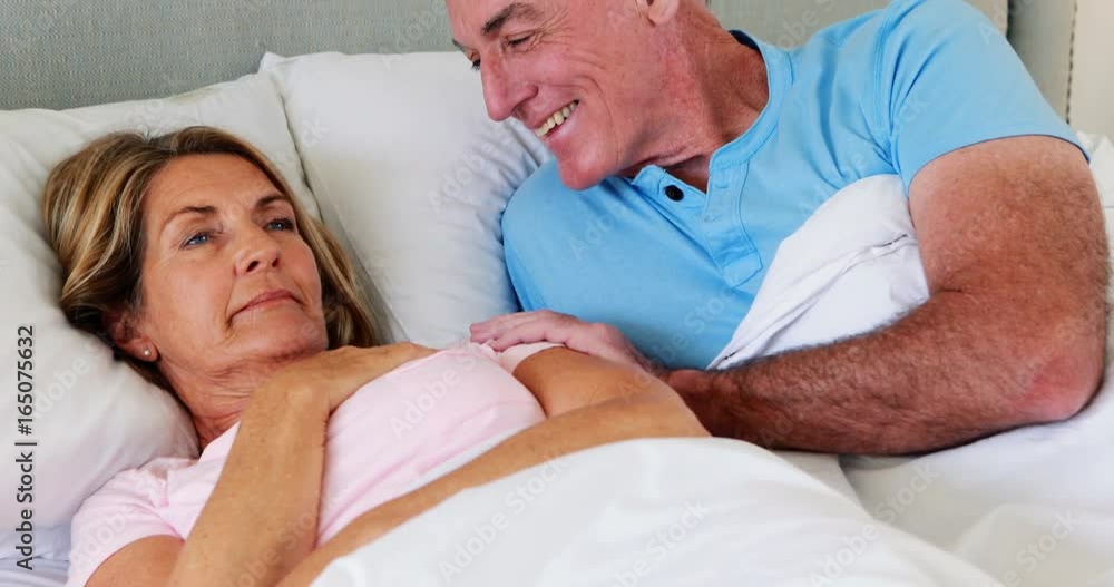Happy senior couple interacting with each other on bed Happy senior couple interacting with each other on bed
