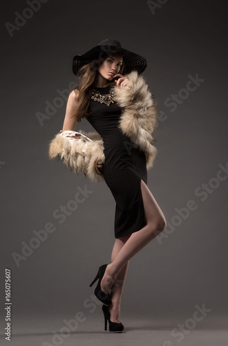 Beautiful, glamorous girl, model in a beautiful evening dress, decoration, outer clothing and hat. Fashion, style, beauty, lifestyle, studio.