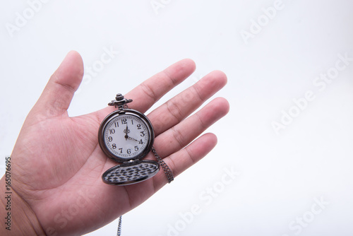 Hand holding an ancient clock watch.