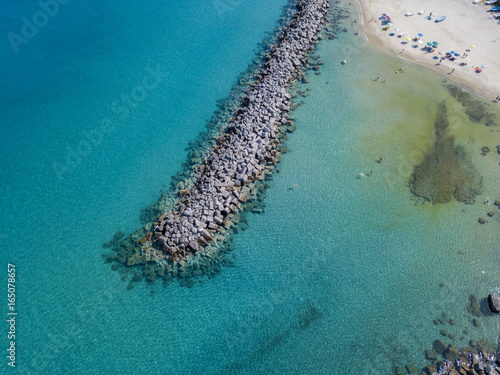 Vista aerea di un molo con rocce e scogli sul mare. Molo di Pizzo Calabro panoramica vista dall’alto. Estate mare e turismo sulle coste calabre del sud Italia. Calabria, Italia