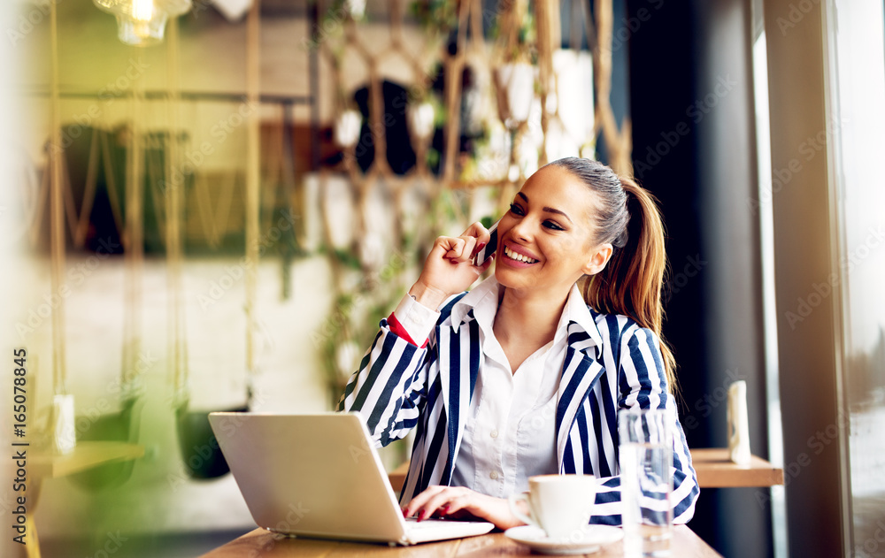 Young pretty businesswoman talking on the phone in coffee shop. Young pretty businesswoman talking on the phone in coffee shop.