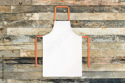 White apron against old wooden background photo