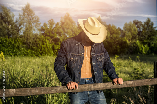 Fotografia Portrait of sexy farmer or cowboy in hat with unbuttoned shirt on muscular torso