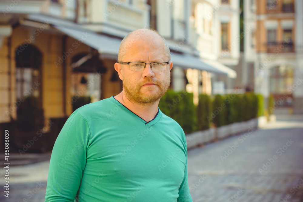 Portrait mature writer hipster man, with red beard walk at the European city Portrait mature writer hipster man, with red beard walk at the European city
