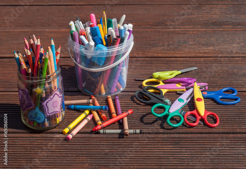 Back to school concept. Pencils markers scissors on wooden background