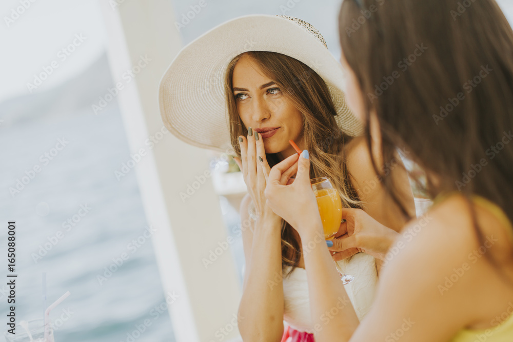 Fototapeta premium Two young women in cafe at sea