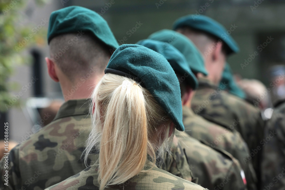A number of soldiers in uniforms of the Polish army including a woman with bright hair