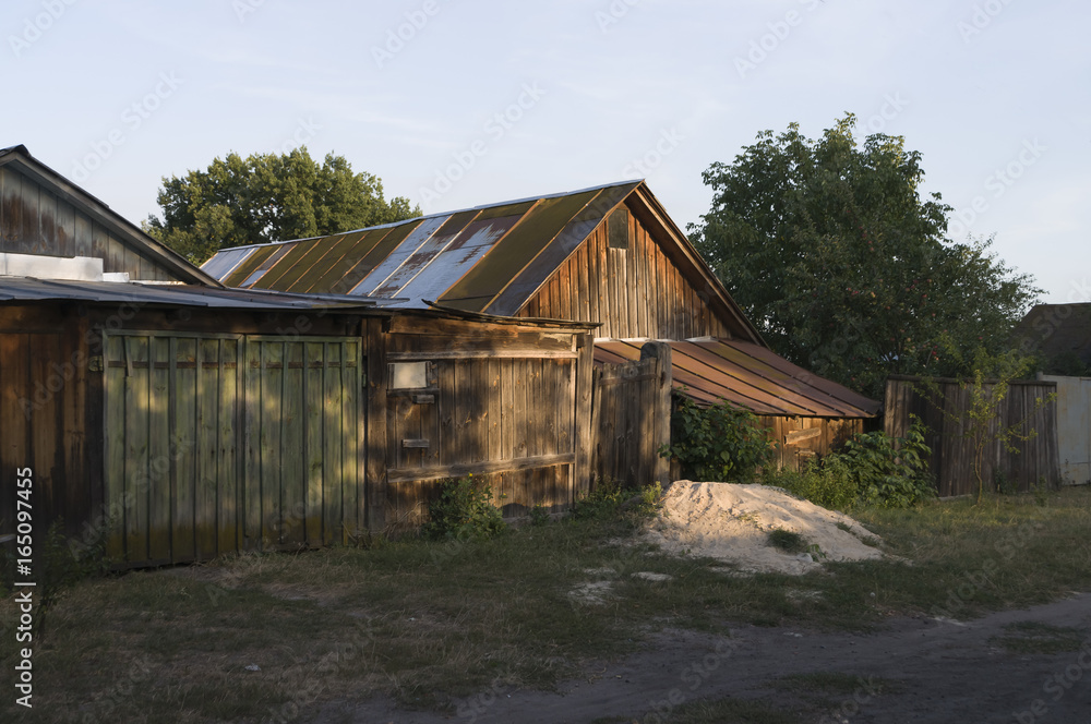 Forgotten old building in little suburb. Early fall trees of green and tint of yellow colors Forgotten old building in little suburb. Early fall trees of green and tint of yellow colors