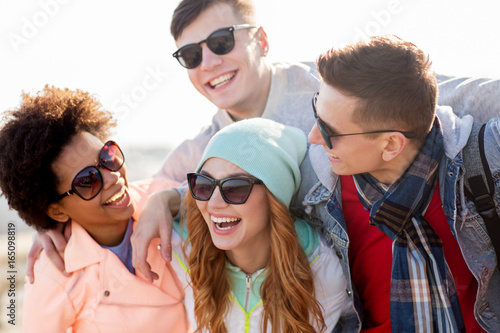 happy teenage friends in shades laughing outdoors