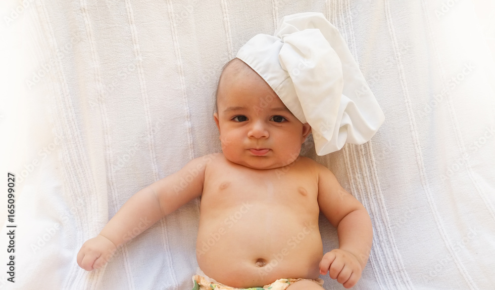 4 months old baby boy , baby chef, baby cook playing with carrots, white background 4 months old baby boy , baby chef, baby cook playing with carrots, white background