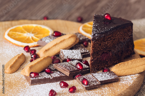 Chocolate cake with pomegranate, bitter chocolate and biscuits. photo