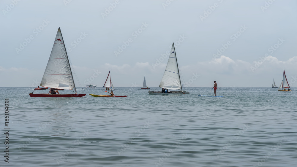 Fototapeta premium Rest on sea. Sea kayak, boats with sail, catamaran, stand up paddler. Outdoor sea sporting activity