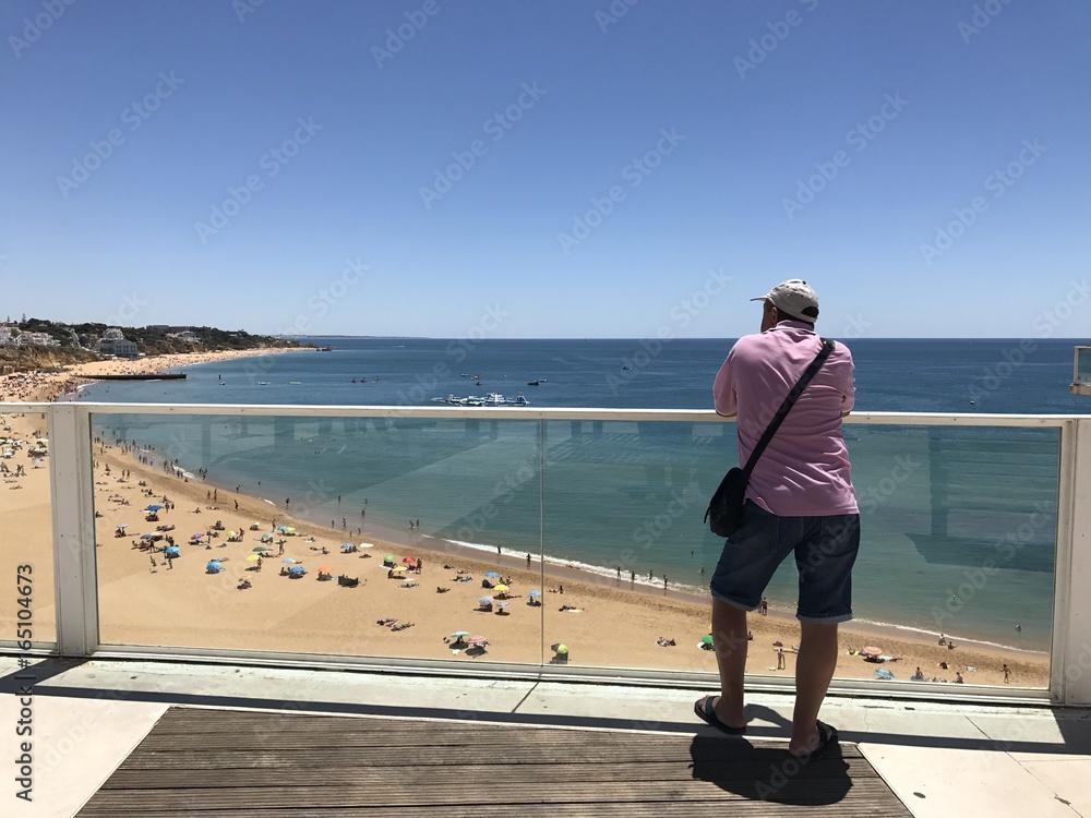 hombre mayor en el mirador contemolando la playa de Albufeira en Portugal