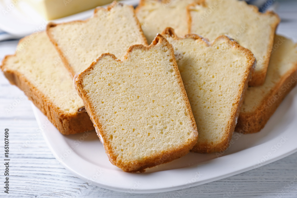 Plate with delicious sliced butter cake on wooden table Plate with delicious sliced butter cake on wooden table