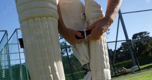 Cricket player tying his batting pads during a practice session photo