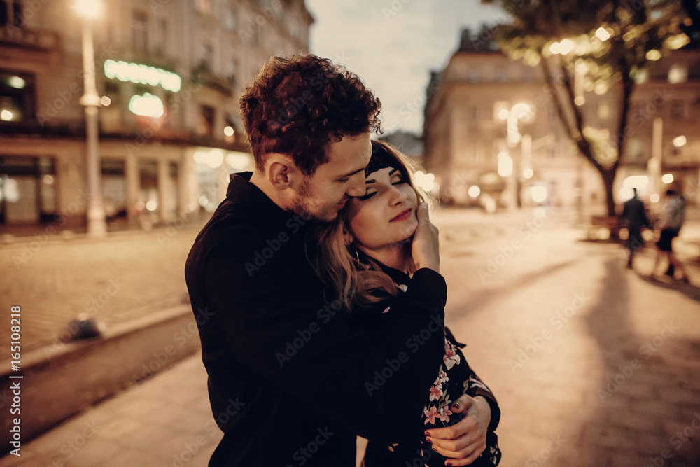 Romantic couple hugging in evening Paris street, handsome bearded