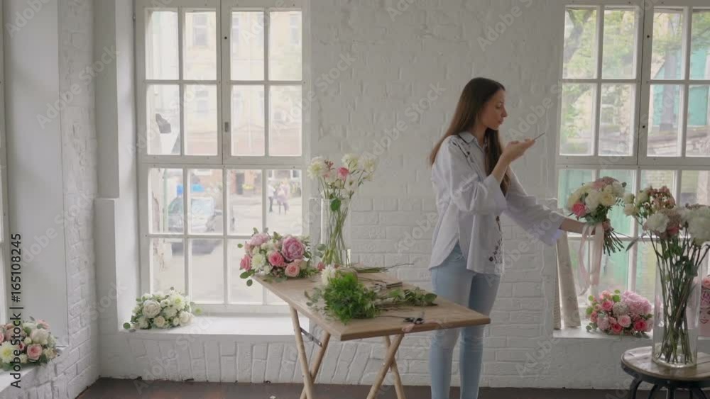 Young florist girl finished making bouquet and making pictures