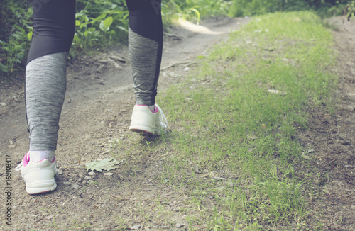 Woman running legs in sunset forest