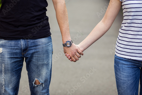 young couple walking in the park and holding hands,A loving couple goes on a picnic