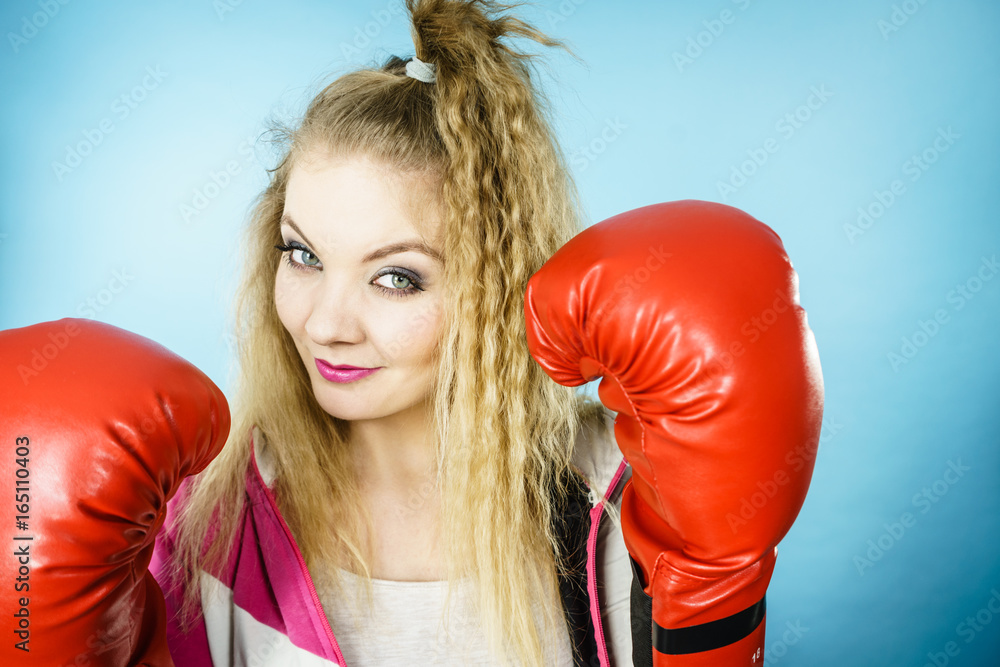 Funny girl in red gloves playing sports boxing