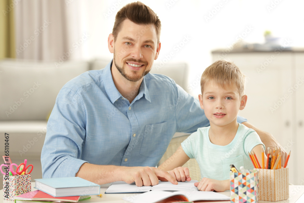 Father and son doing homework together at home Father and son doing homework together at home