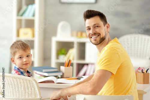 Father and son doing homework together at home