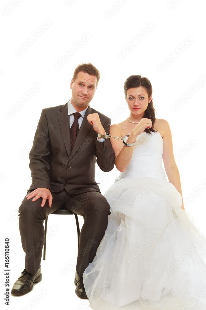 Bride and groom in handcuffs wearing wedding outfits Bride and groom in handcuffs wearing wedding outfits