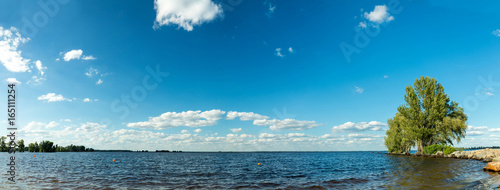 Fototapeta Naklejka Na Ścianę i Meble -  Cityscape and skyline in cloudy sky and river. Sunshine, blue sky. Boats on the water. Panorama.