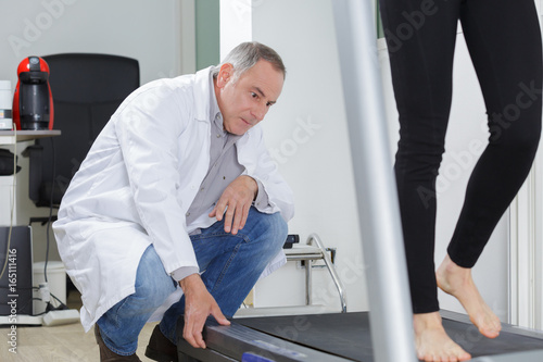 Fotografia Specialist watching woman walk on tread mill