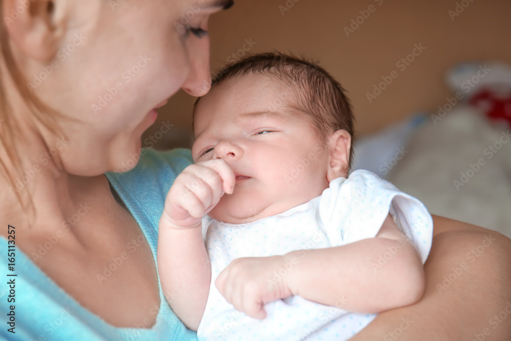Happy young woman holding her newborn baby boy, closeup