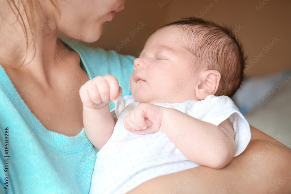 Happy young woman holding her newborn baby boy, closeup Happy young woman holding her newborn baby boy, closeup