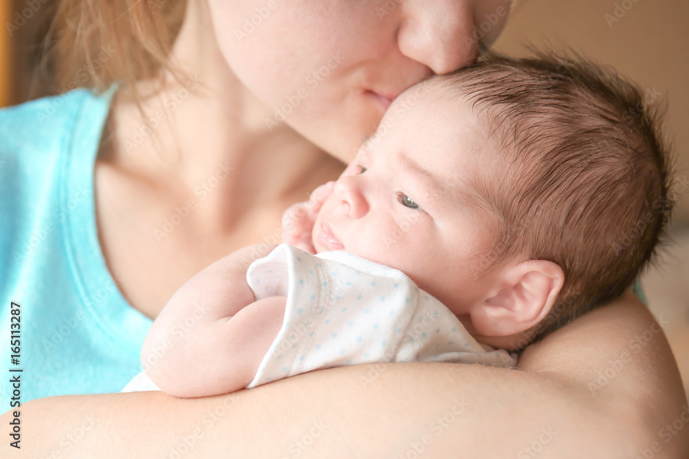 Happy young woman kissing her newborn baby boy, closeup Happy young woman kissing her newborn baby boy, closeup