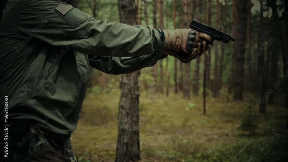 special forces soldier shoots a handgun on a patrol in the woods special forces soldier shoots a handgun on a patrol in the woods