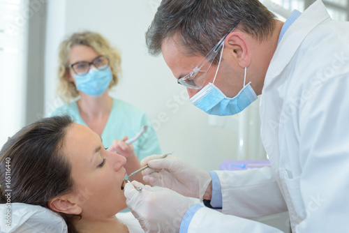 Dentist inspecting patient's teeth