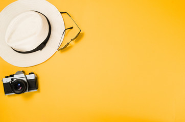 Accessories for travel top view on yellow background with copy space. Beach adventure and wanderlust concept image with travel accessories. Sunbathing and relaxing