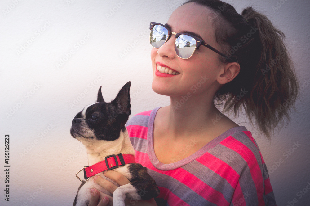 Young modern smiling woman with her dog in a casual attitude