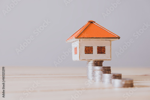 paper house with key on wooden wall background © doidam10