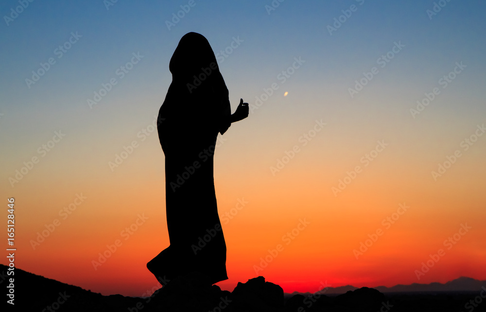 Arabian nights. Woman in black dress abaya with scarf around head