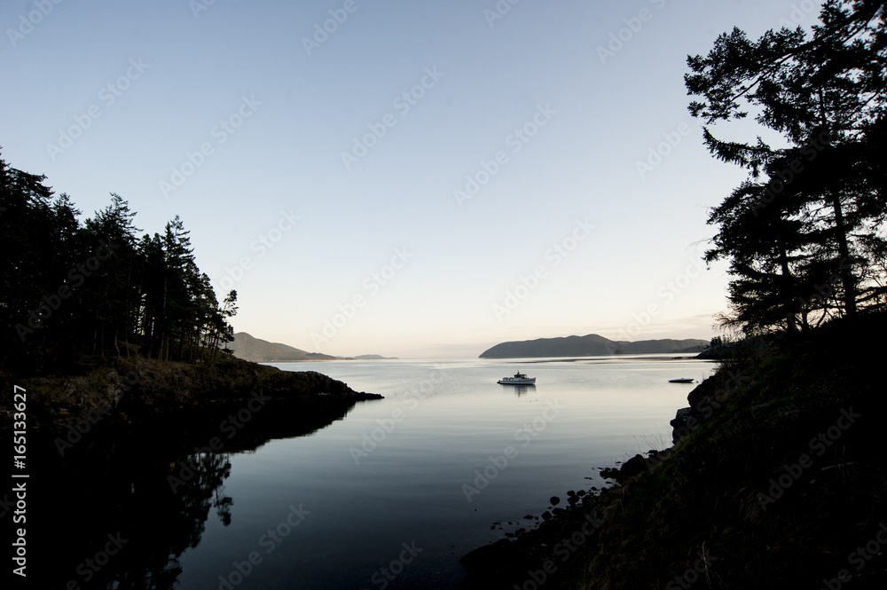 Silhouette of a single boat on the bay at dusk Silhouette of a single boat on the bay at dusk