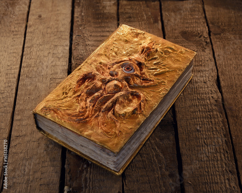 Fotografie Close up of magic book with golden cover and marine monster image