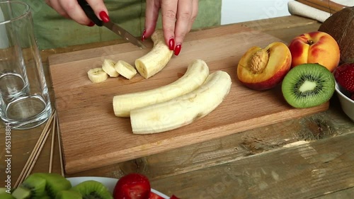 Woman on a cutting board stealing a banana knife. Camera moves from left to right photo