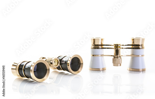 Two Pairs of opera glasses on a white background with refection and copy space